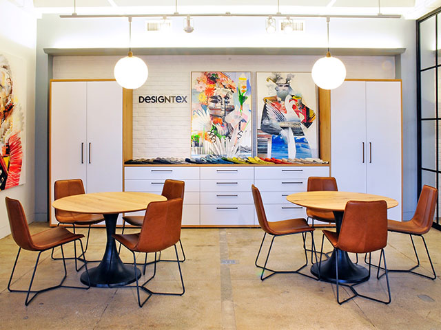 An intimate dining area with storage cabinetry in West Elm Furniture at the Empire Showroom space. Leather bucket chairs pedestal tables provide seating.