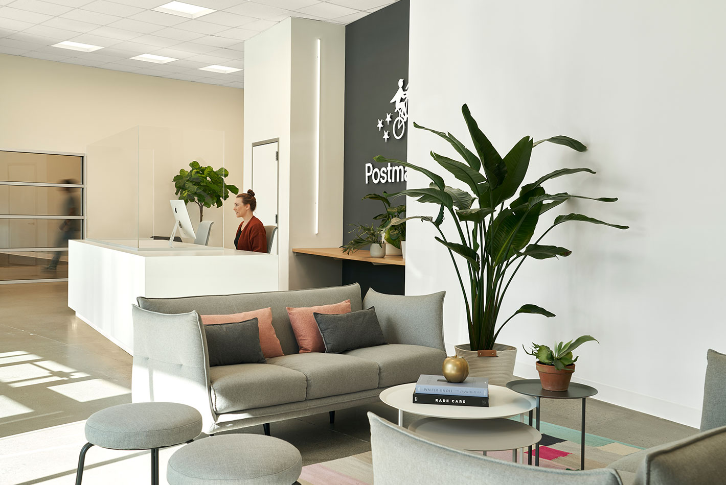 Pale gray upholstered pieces create a waiting area in Postmates Headquarters reception area.