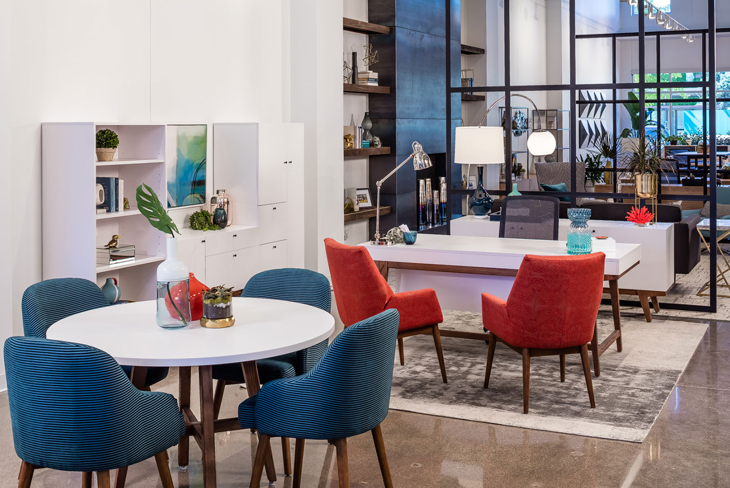 A long view into the Minneapolis Workspace showroom of West Elm furniture. Several different furniture collections, some blue and some red, are feature side by side.