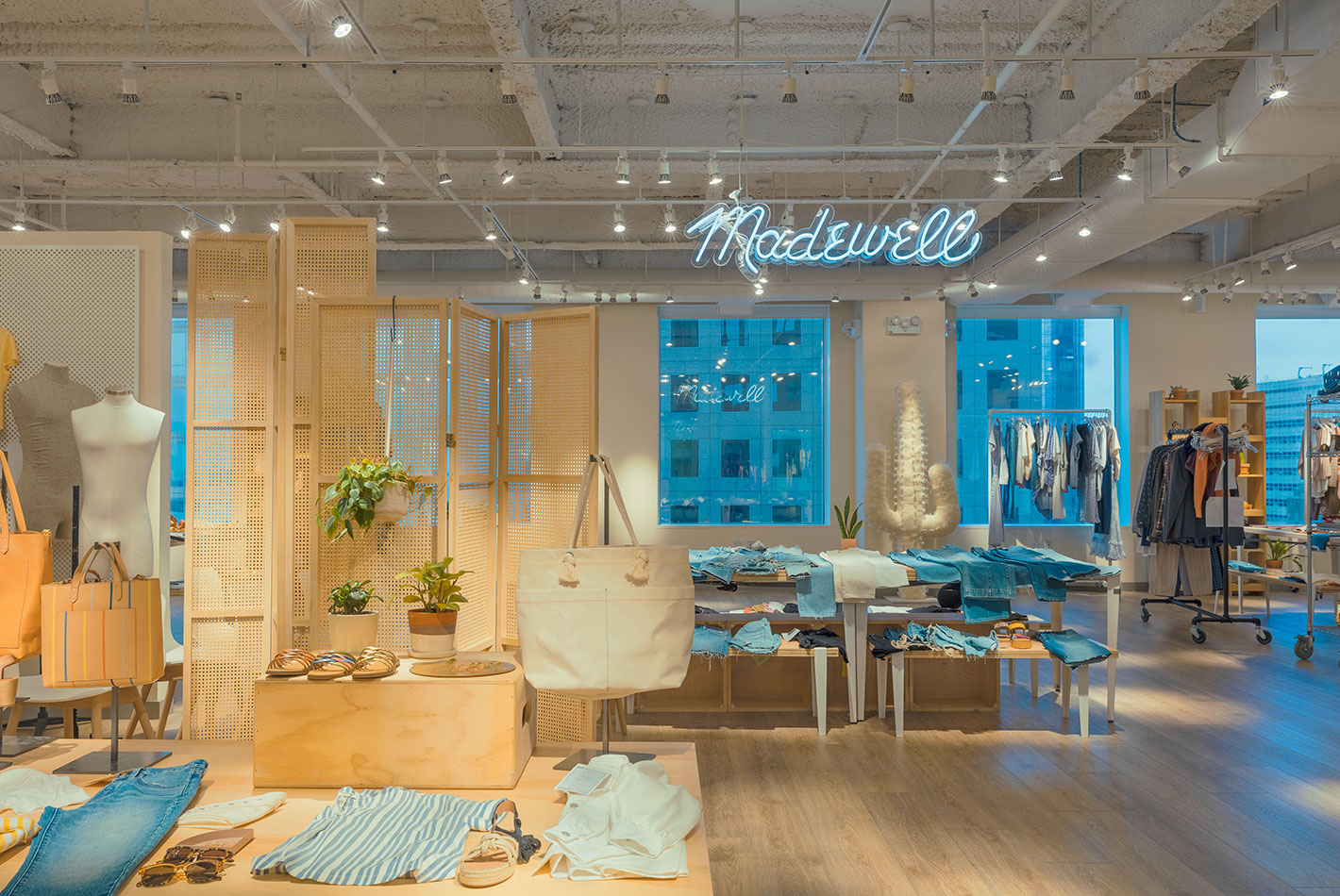 The woman's accessories area at the Madewell store in Hudson Yards features natural light from full windows and ceiling fixtures. Bleached oak floors add a natural note.