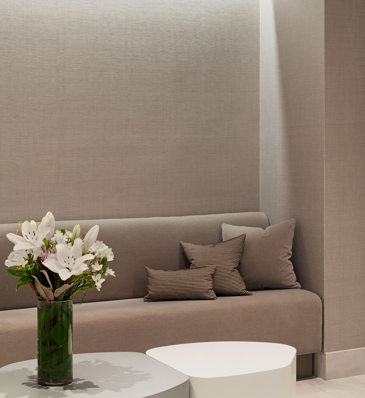 A modern taupe-colored banquette in the lobby of 1056 5th Avenue