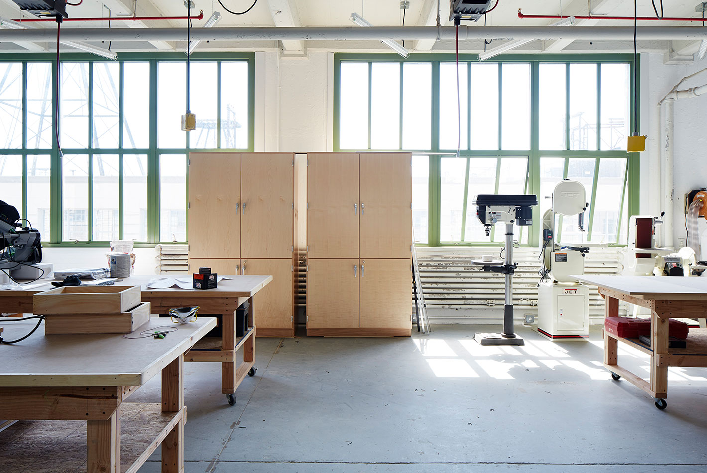 A light-filled workspace inside West Elm's Maker's Studio. Industrial tables and shelves populate the room