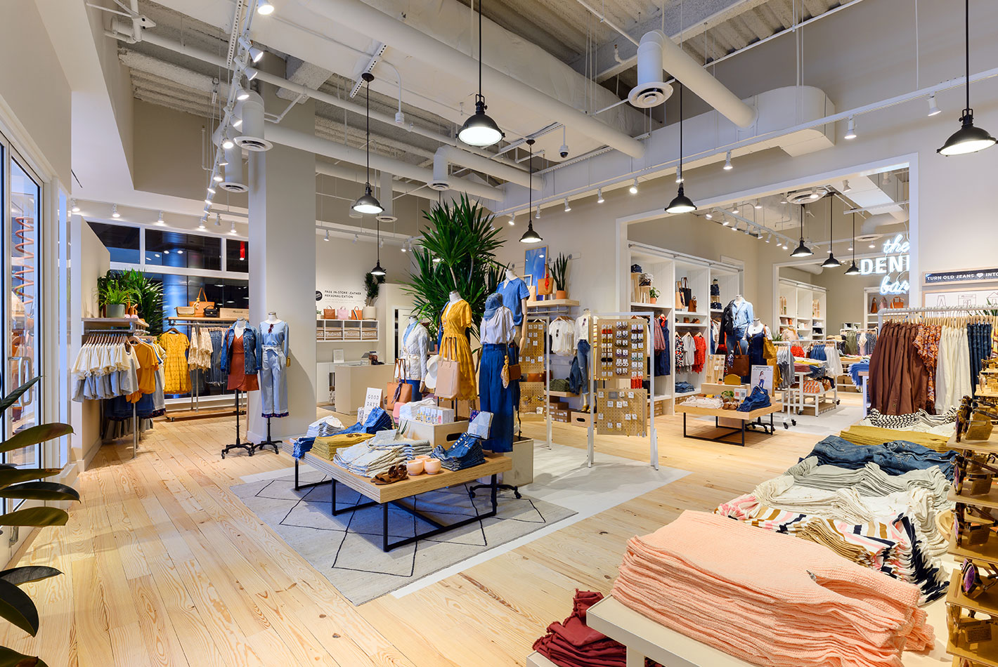 The women's department at Madewell features a collection of indigo-hued clothing and accessories. Jeans, t-shirts, and dresses are displayed around the space.