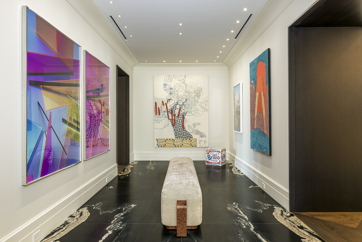 Gallery space with marble floor and contemporary art collection on white walls